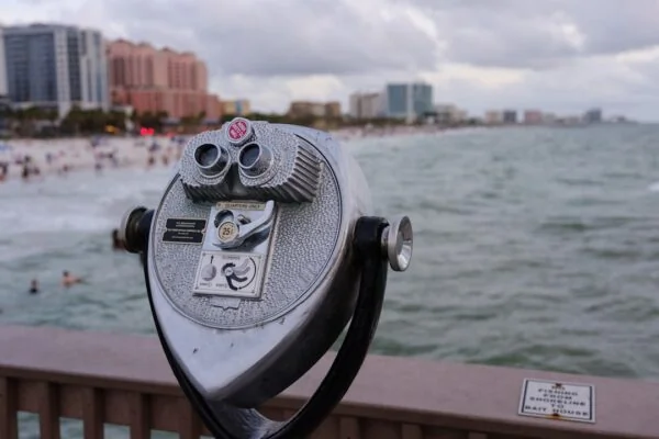 gray coin operated binoculars on brown wooden table