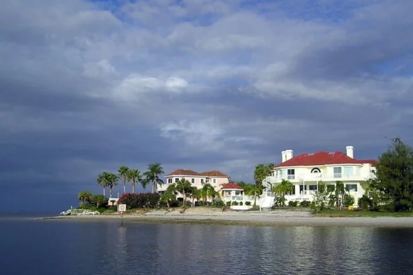 a large white house sitting on top of a beach