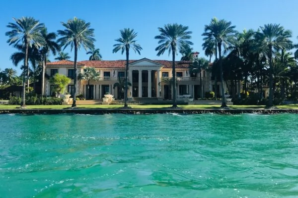 brown and white concrete house near body of water ahead