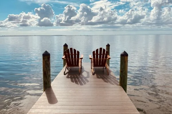 brown wooden dock on sea under blue sky during daytime