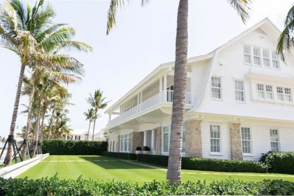 white wooden house near palm trees