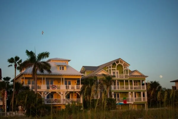 A large yellow house sitting on top of a lush green field